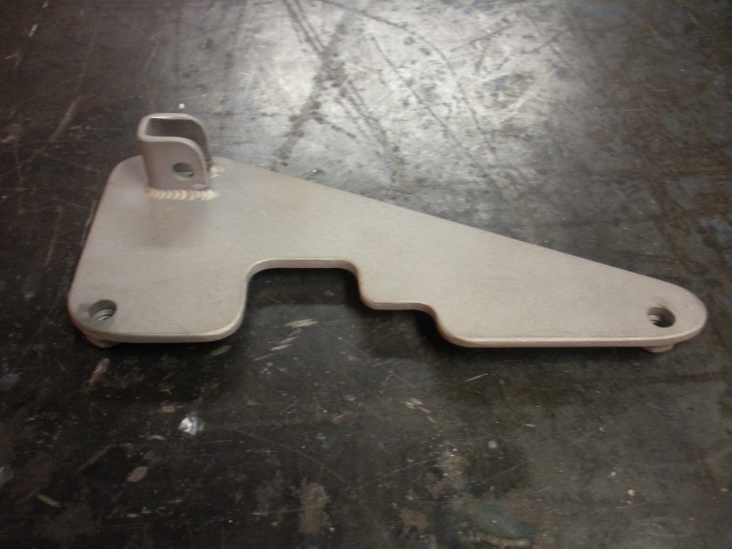 A metal piece of art that is sitting on the ground.