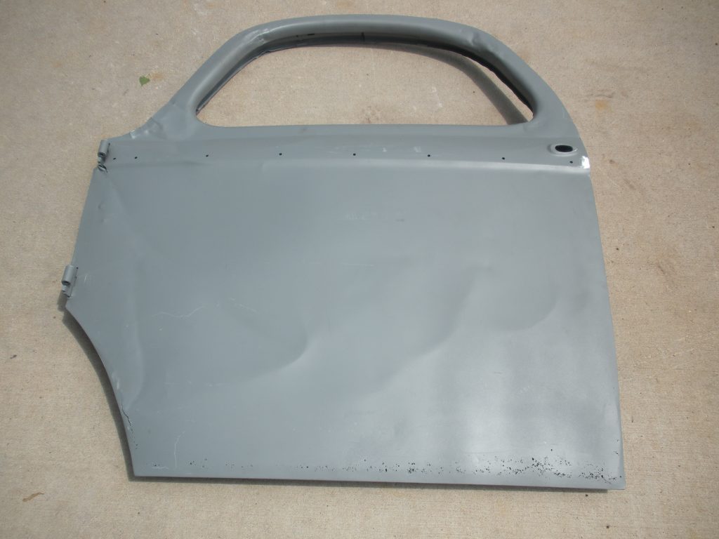 A gray door panel is shown on the floor.