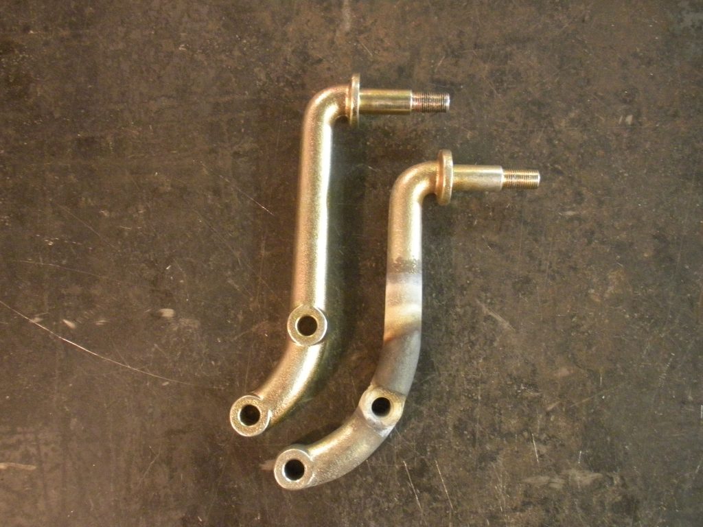 A pair of brass handles for a motorcycle.