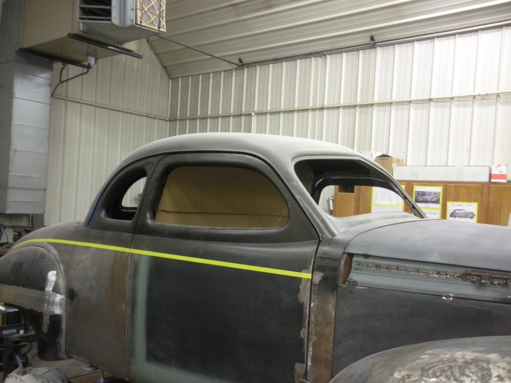 A car that is in the garage with some paint on it.