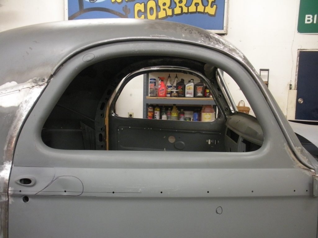 A car with the door open and a bookshelf in the background.