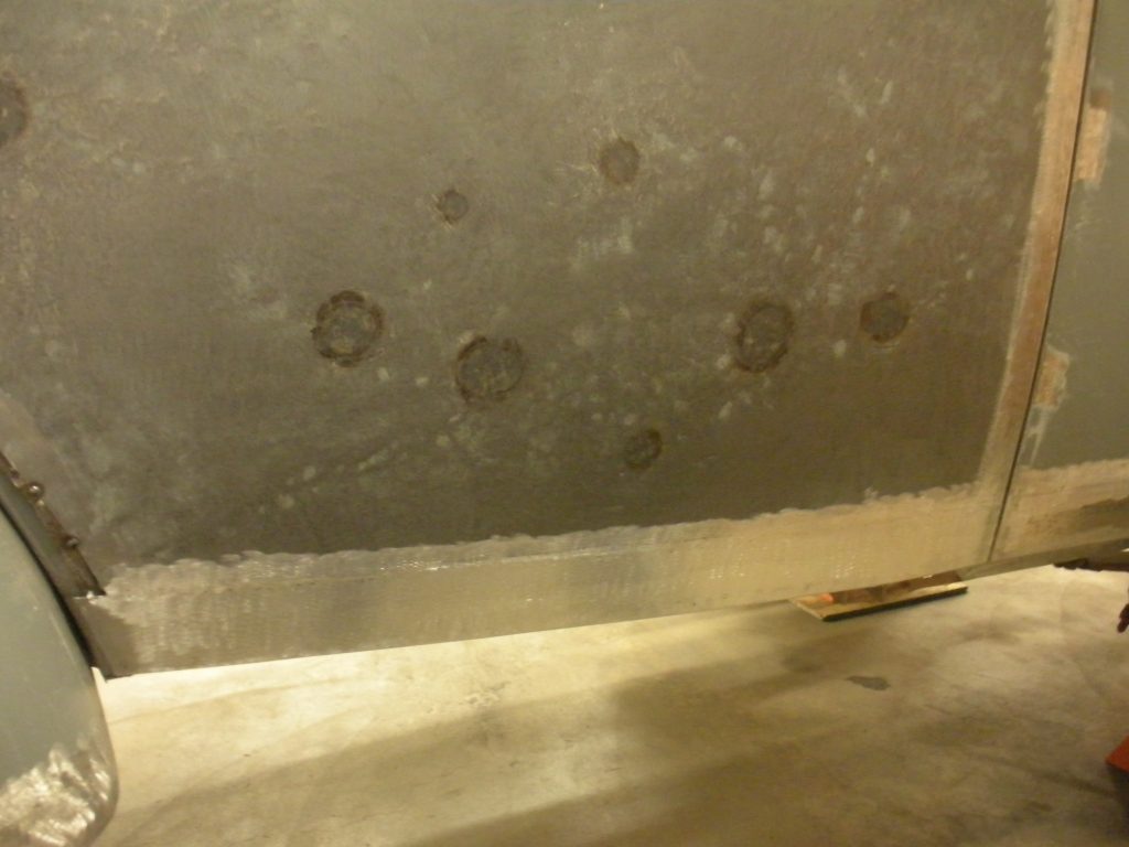 A wall with holes in it and some concrete