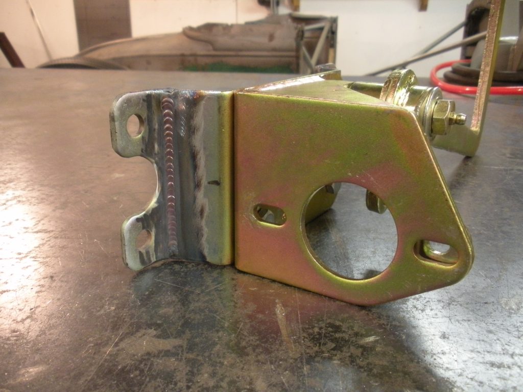A close up of the side of a yellow metal object.