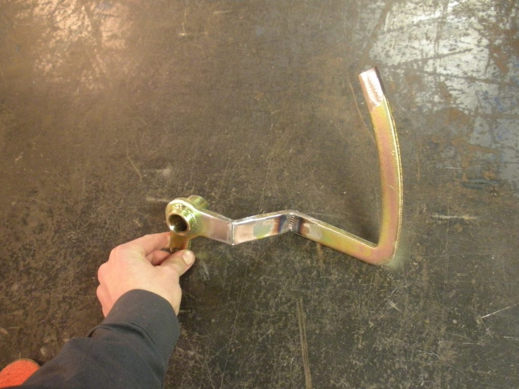A person holding a wrench on the ground