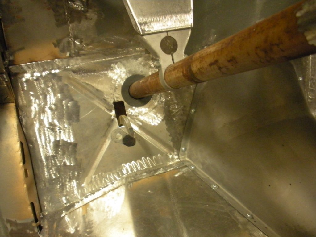 A metal sink with wooden handles and a hole in it.