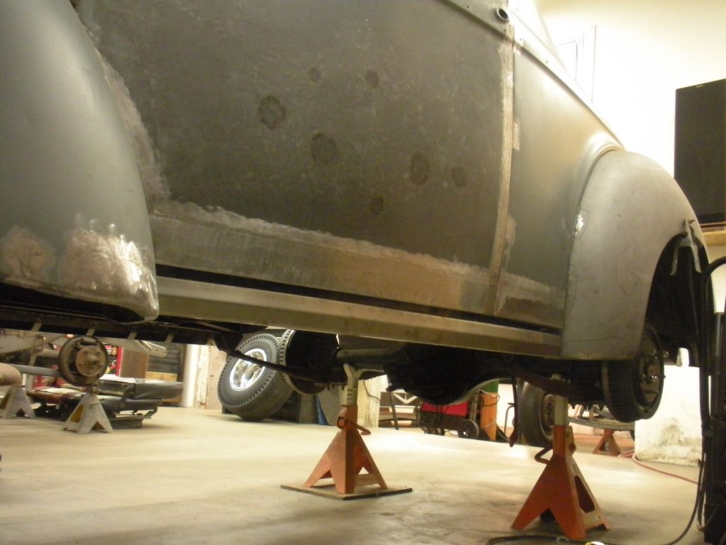 A car is parked in the garage with its front end being lifted.