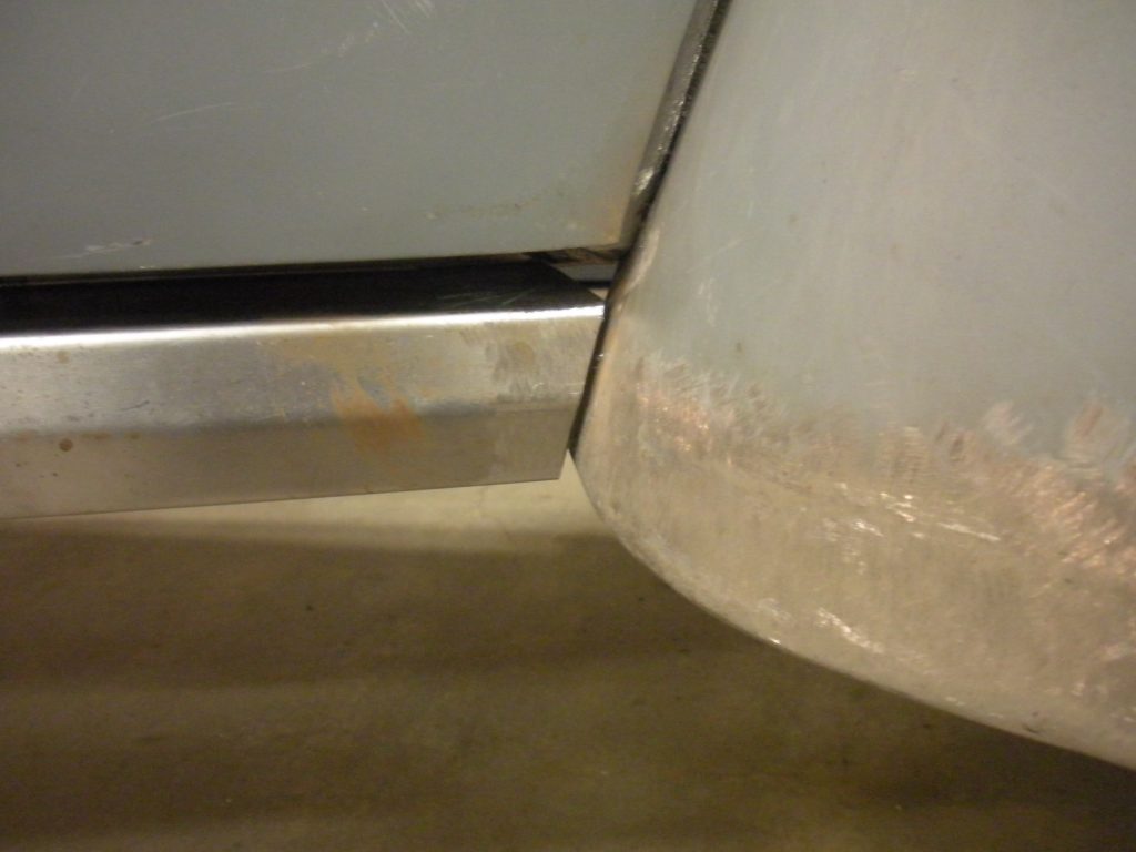 A corner of the floor with some rust on it