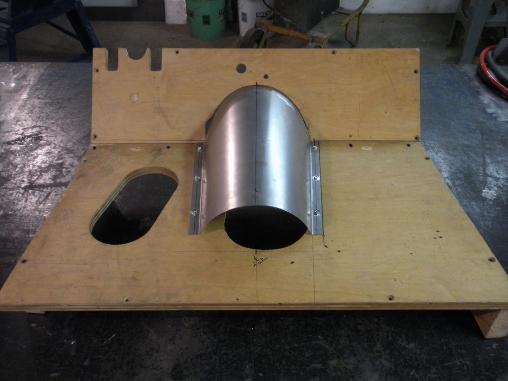 A metal pipe sitting on top of a wooden board.