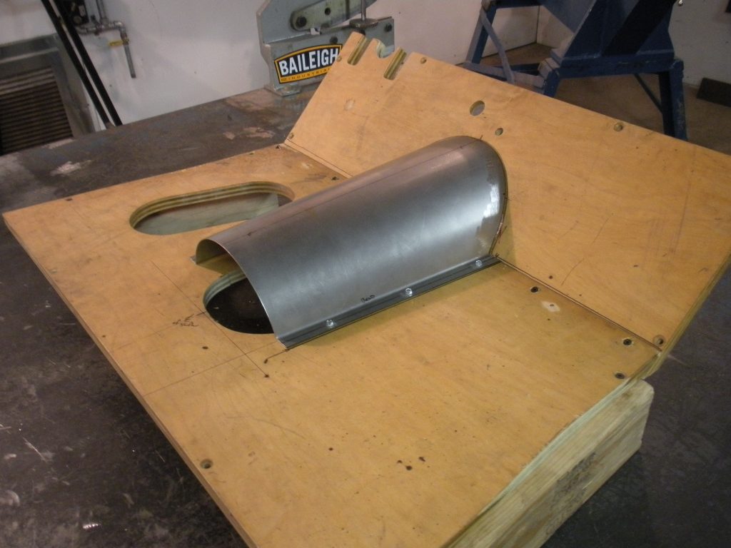 A piece of wood with a metal pipe on it.