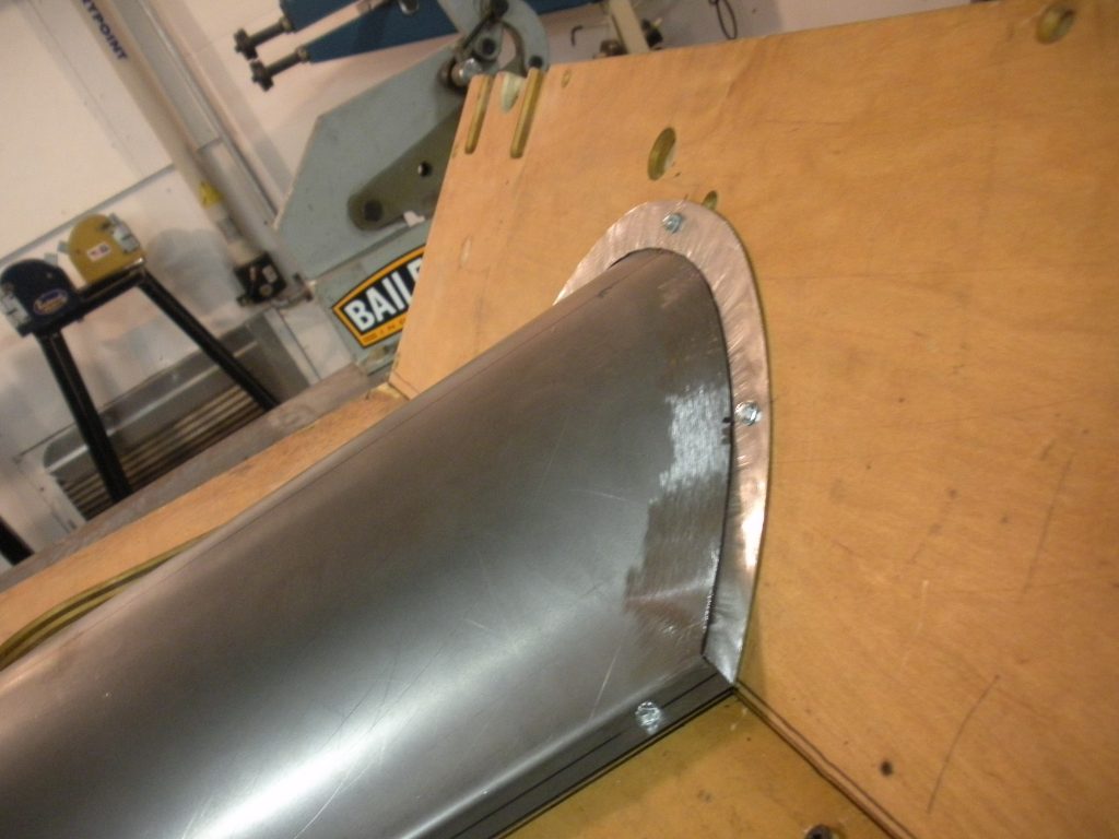 A metal pipe sitting on top of a wooden table.