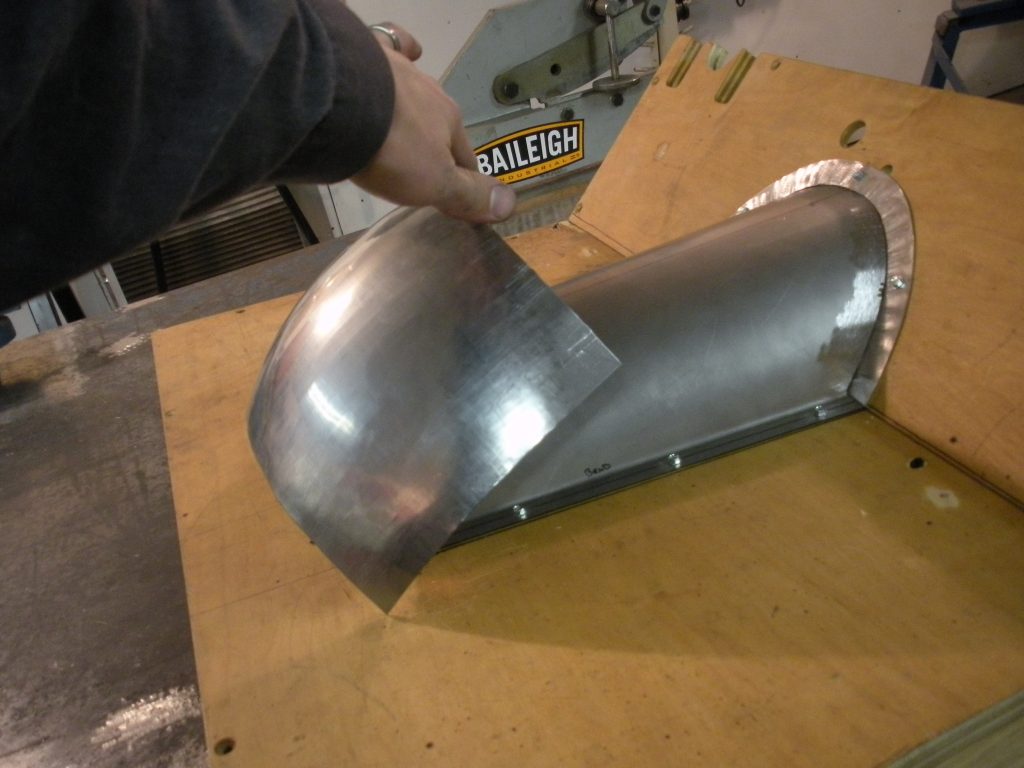 A person is bending the metal sheet over.