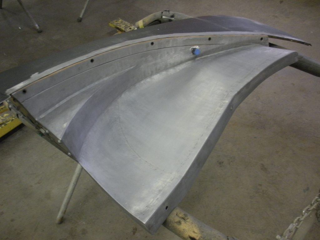 Gray metal car part in progress.
