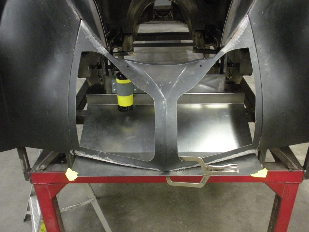 Car body panel being clamped for welding.