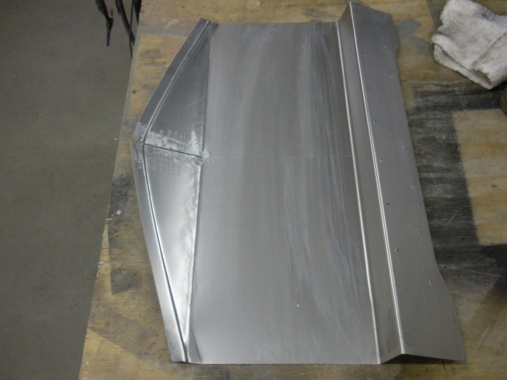 Here's an alt tag for the image: Metal car part, sanded smooth.