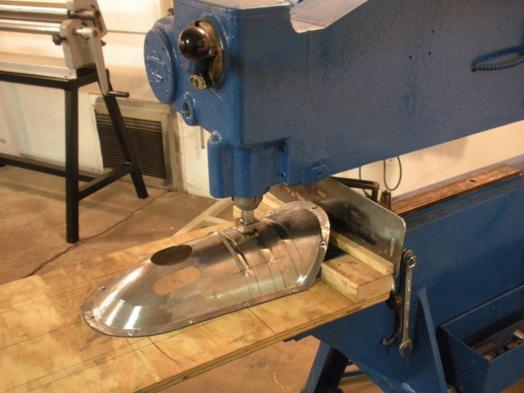A metal object is being worked on by a machine.