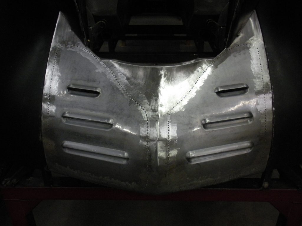 Here's an alt tag for the image: Metal car body panel, under construction.