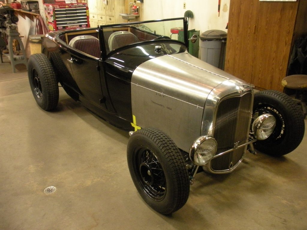 A black and silver car is parked in the garage.