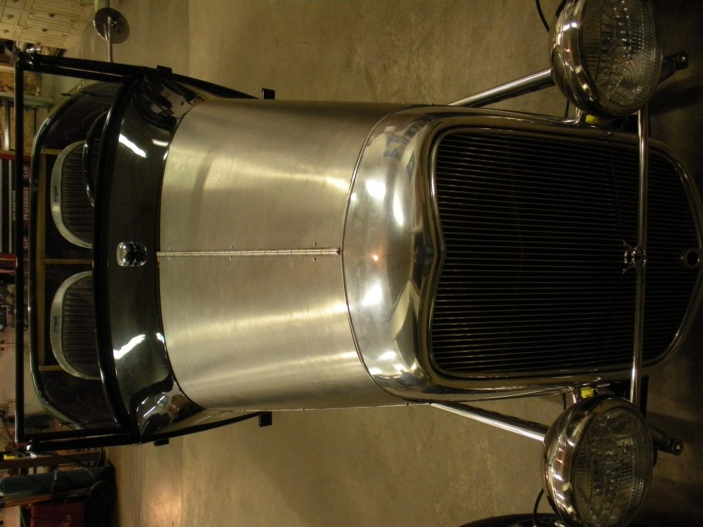 A close up of the front end of an antique car.