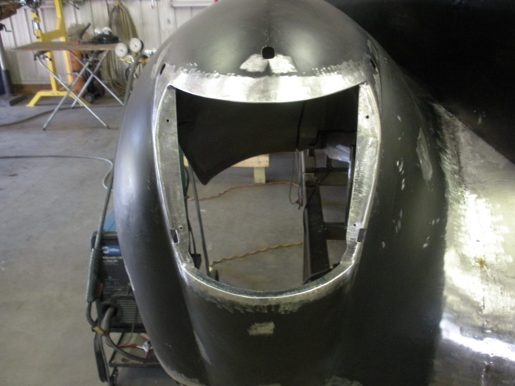 Car body headlight area welding in progress.