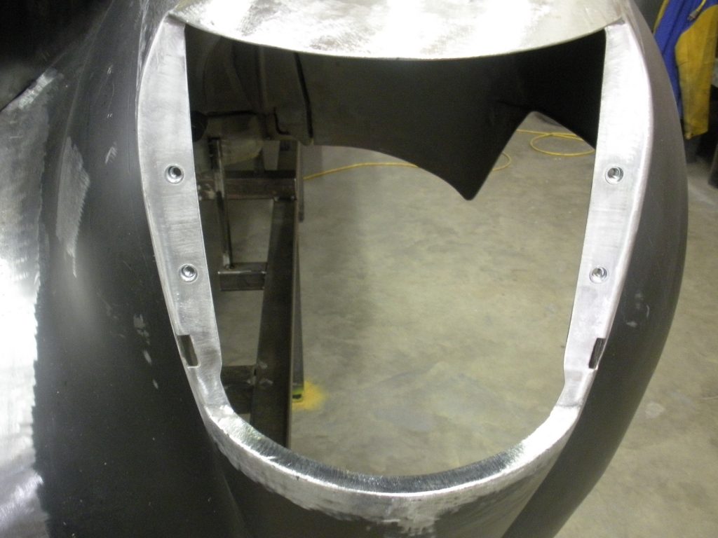 Metal car part with bolt holes.