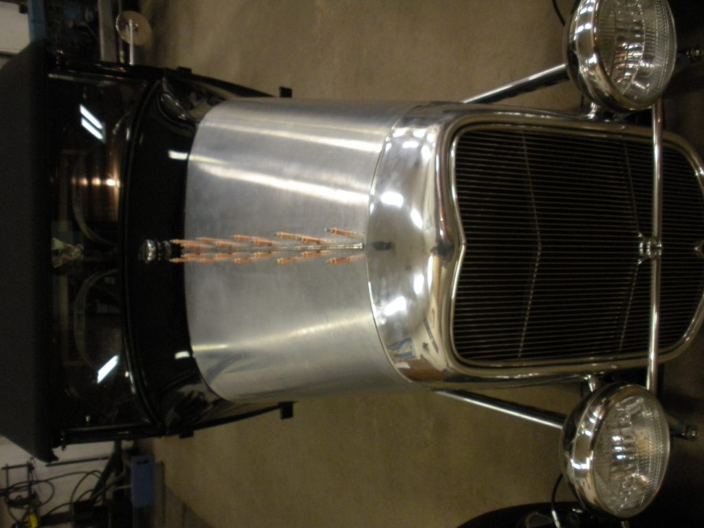A close up of the front end of an antique car.
