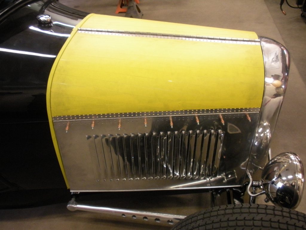 A close up of the radiator cover on an old car.