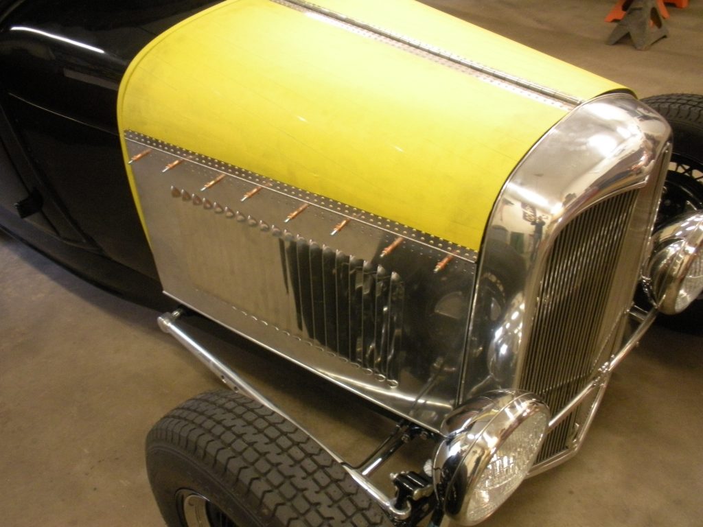 A yellow and silver car with tire on the floor.