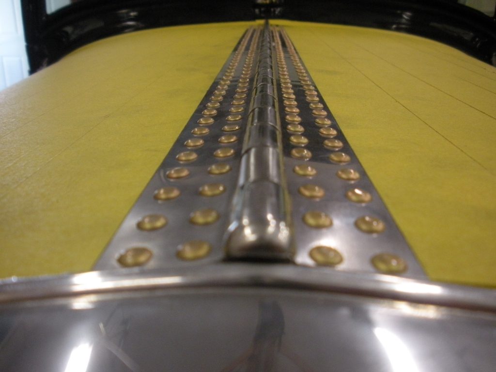 A close up of the metal part on a yellow table.