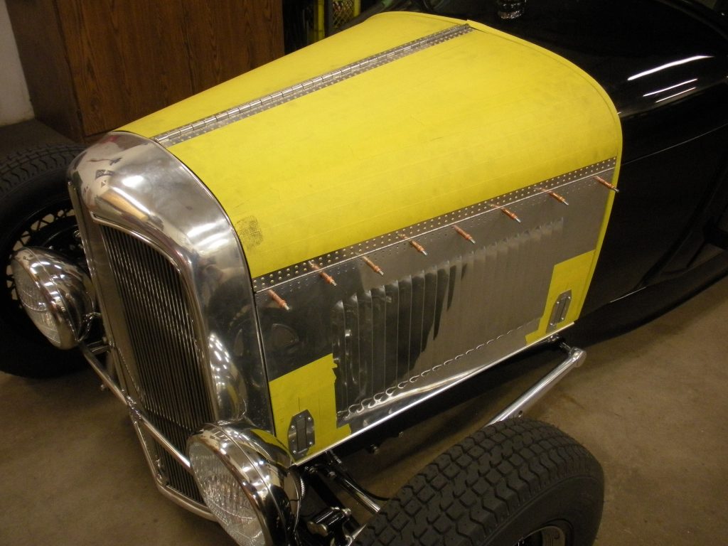 A yellow and silver car with a tire on the floor.