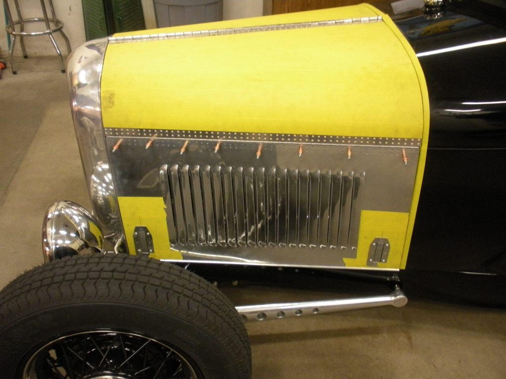 A yellow and black car with a grill on it