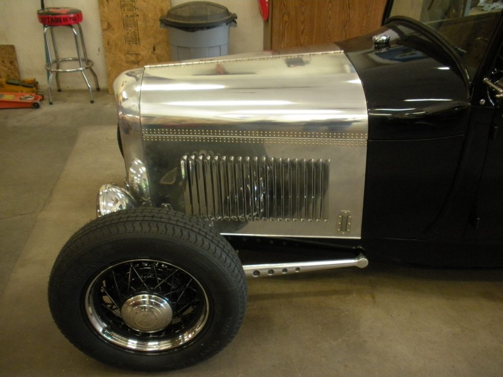 A black and silver car with a tire on the floor.
