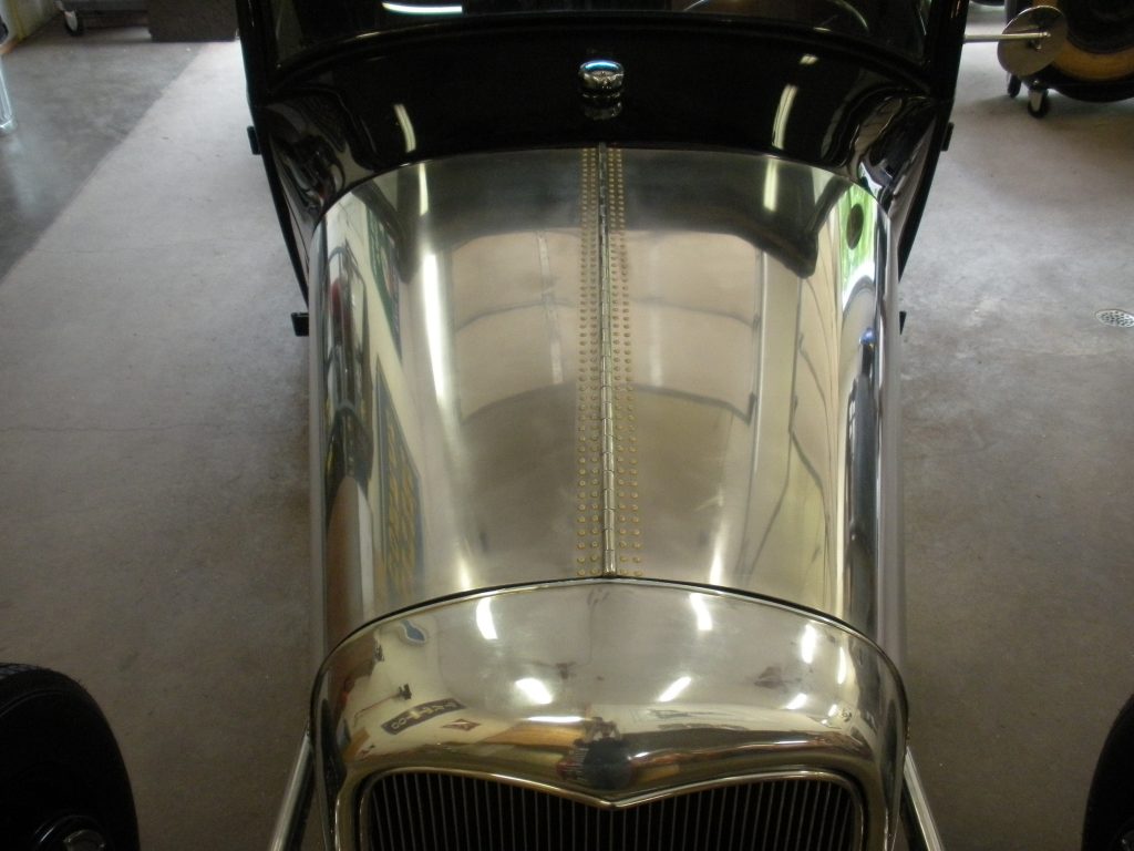 A close up of the hood on an old car