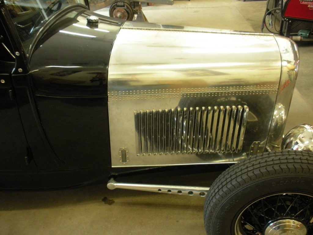 A black and silver car with a tire on the floor