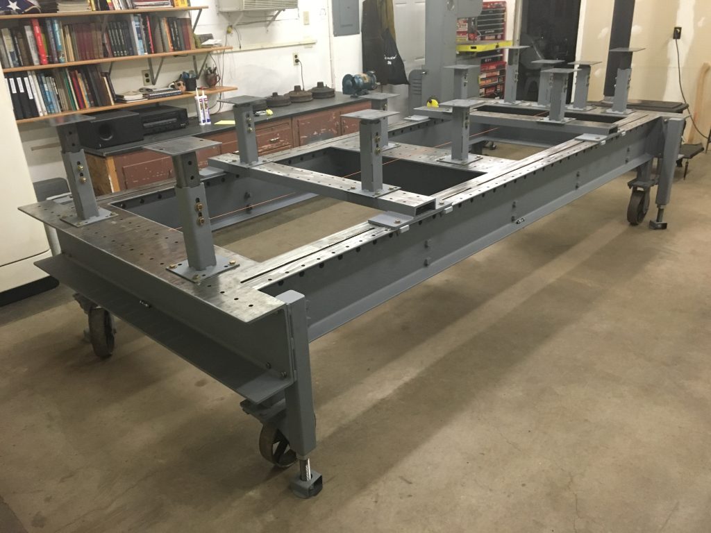 A table with metal legs and wheels on the floor.