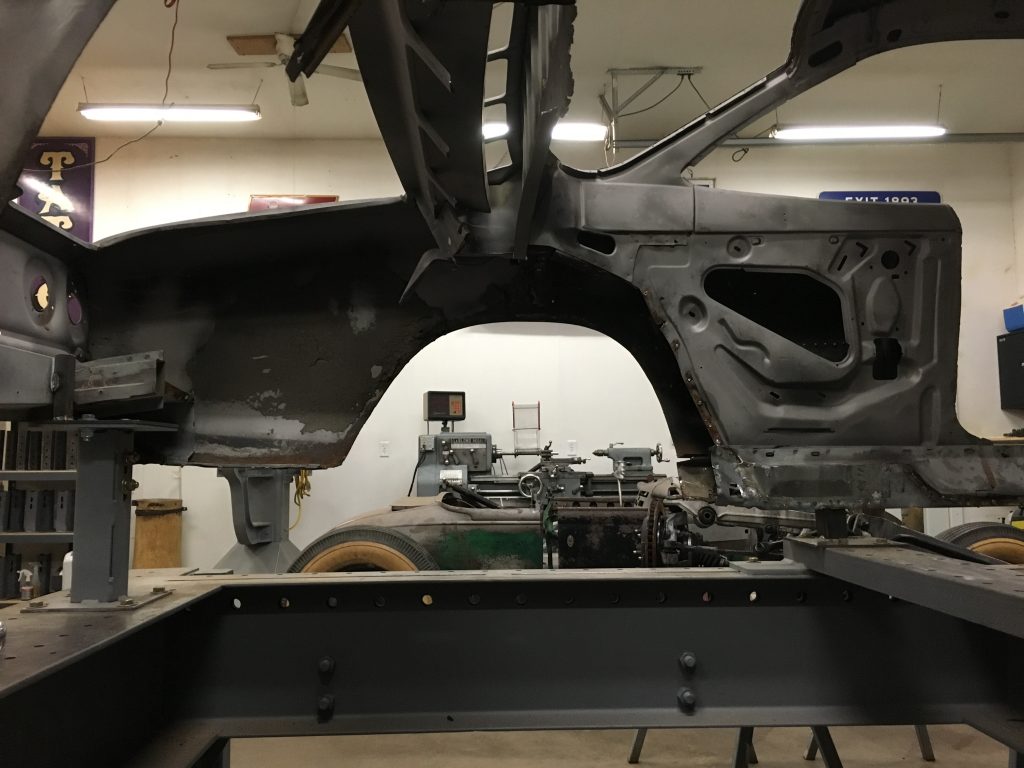 A car frame being worked on in a shop.