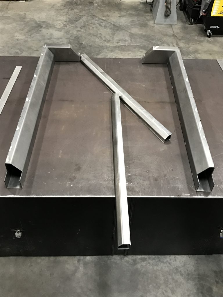 A metal table with two pieces of steel.