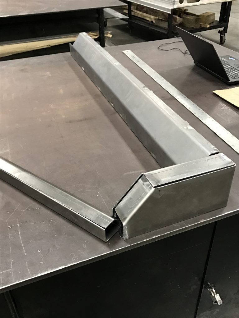 A metal table with a laptop on it