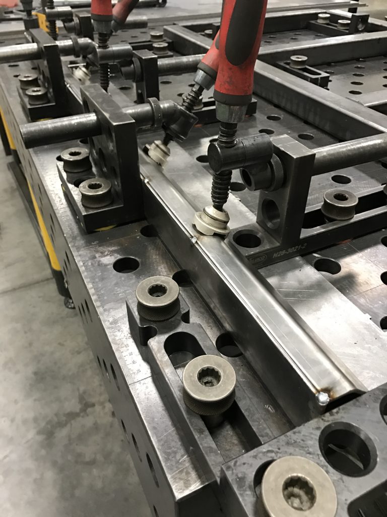 A machine is cutting metal with a pair of wrenches.