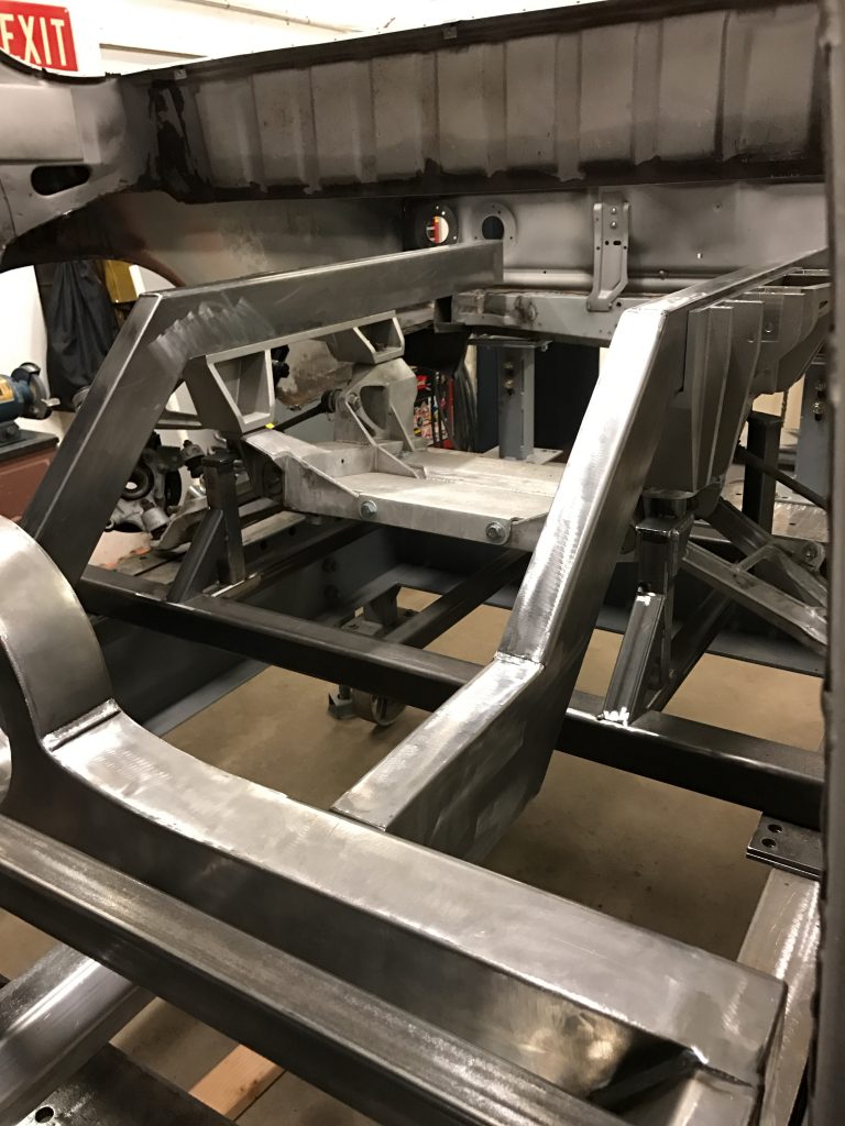 A man working on the frame of a car.