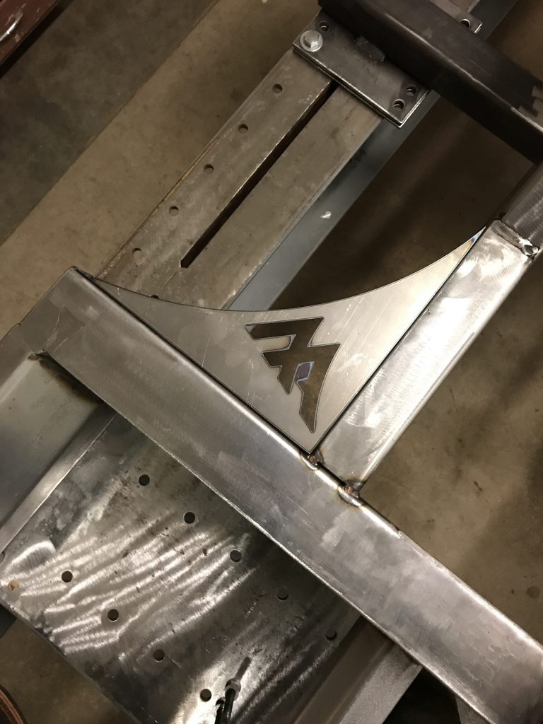 A metal piece of art with the letter e on it.