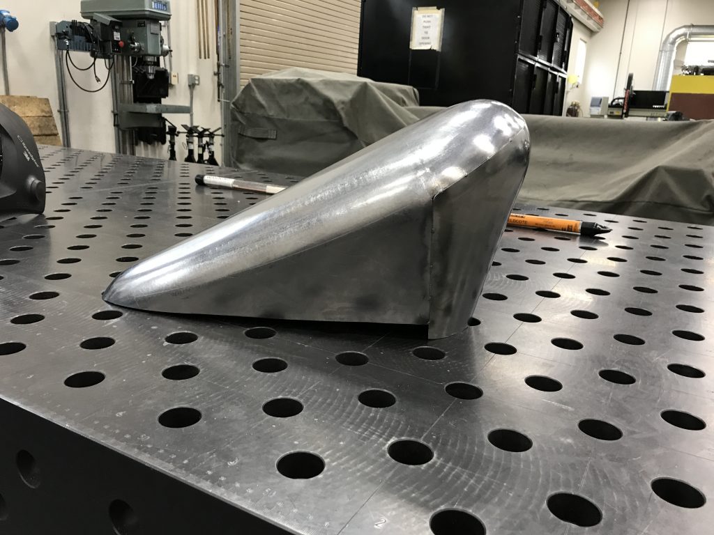 Metal part on perforated metal table.