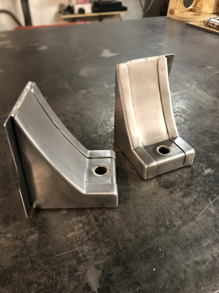 A pair of metal brackets sitting on top of a floor.