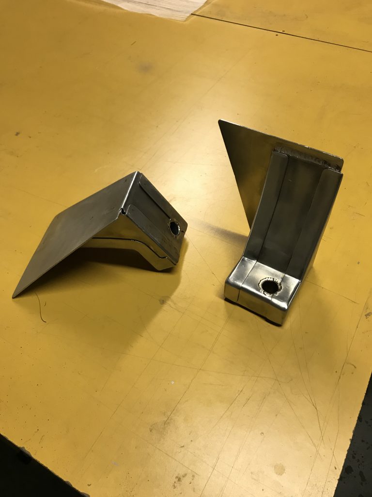 A pair of metal bookends on top of a table.