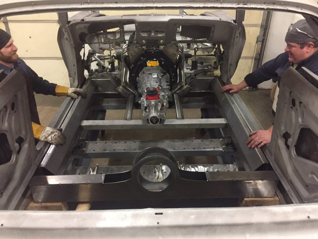 A car being worked on by two men.