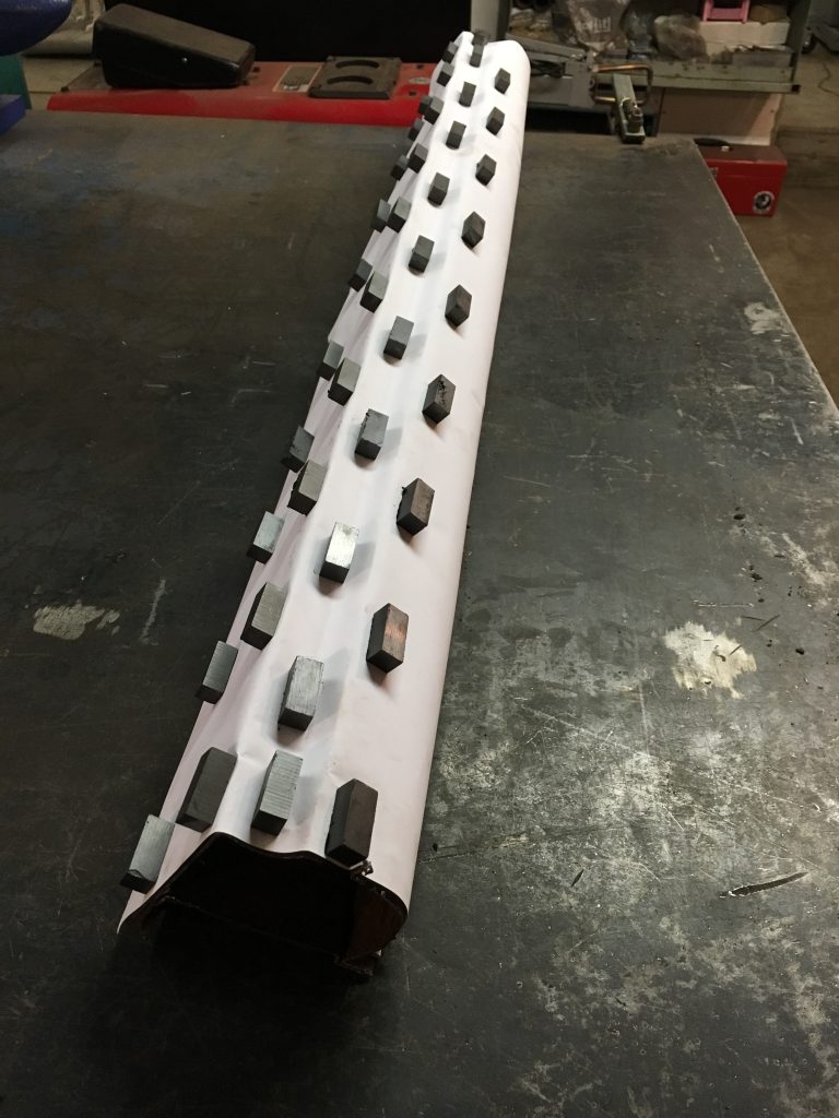 Here's an alt tag for the image: Magnets attached to rolled paper.