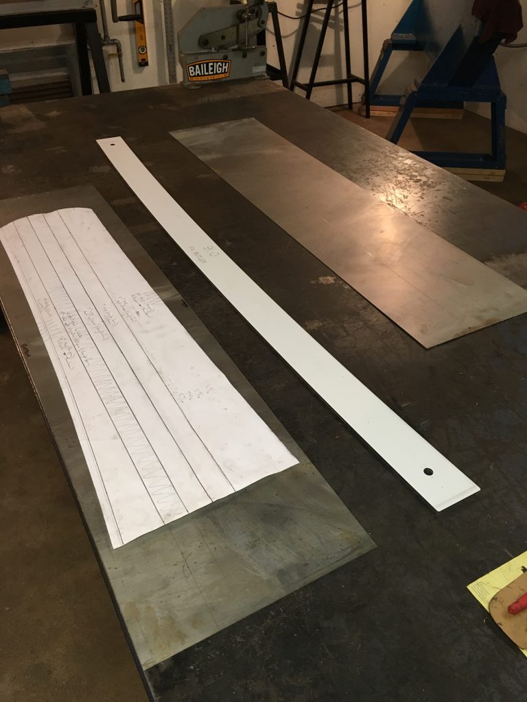 Metal sheet and cutting template on table.
