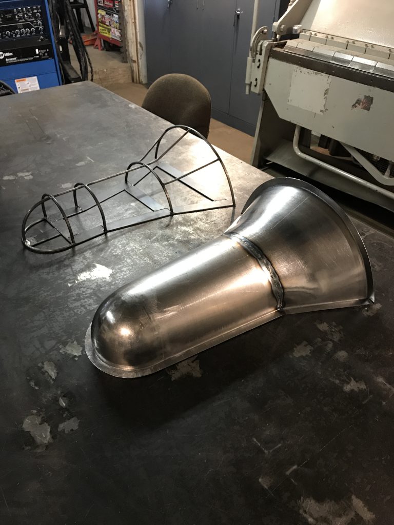 Welded metal parts on workbench.