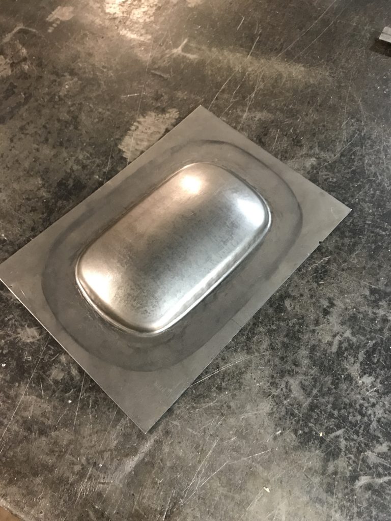 Metal sheet with formed recess.